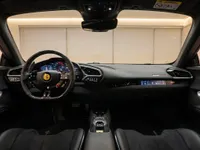 The luxurious black interior and dashboard of the Ferrari 296 GTS, featuring the steering wheel and central console in Zurich.
