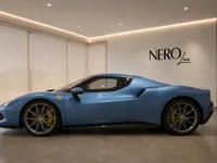 The blue Ferrari 296 GTS is showcased in a modern showroom in Zurich, viewed from its elegant side profile.