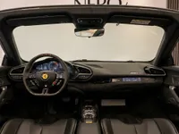 The luxurious cockpit of the 2023 Ferrari 296 GTS in Zurich, featuring its advanced steering wheel and digital dashboard.