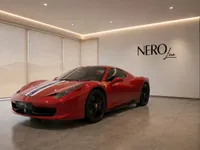 The red Ferrari 458 Spider, featuring distinctive racing stripes, is elegantly displayed in a modern NEROline showroom in Zurich.