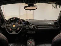 The luxurious black leather interior of the Ferrari 458 Spider in Zurich, showcasing the steering wheel, dashboard, and red stitching.