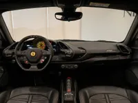 The luxurious black leather interior and dashboard of the Ferrari 488 Spider in Zurich, showcasing its advanced cockpit.