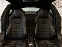 The luxurious black leather interior seats of the Ferrari 488 Spider are visible, with the powerful engine partially seen through the rear window in Zurich.