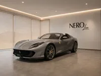The grey Ferrari 812 GTS convertible is showcased in a modern showroom with the NEROline logo in Lausanne.