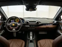 The luxurious brown leather interior of the Ferrari 812 GTS, showcasing the dashboard, steering wheel, and central console in Lausanne.