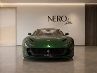 The gloss dark green Ferrari 812 GTS is showcased in a modern Zurich showroom, featuring its striking front design.