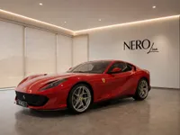 The red Ferrari 812 Superfast is parked in a modern showroom with the NEROline logo on the wall in Lausanne.