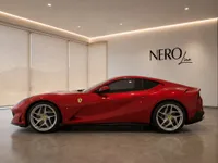 The stunning red Ferrari 812 Superfast is showcased from its side profile in a modern showroom in Lausanne.