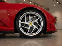The gleaming red Ferrari 812's front wheel and fender are showcased in a showroom in Lausanne.
