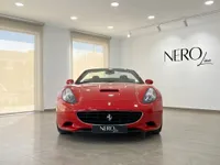 이비자 쇼룸 내부에 NEROline 로고와 함께 빨간색 페라리 캘리포니아 T 컨버터블이 정면에서 돋보이게 전시되어 있습니다.