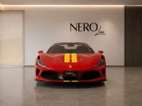The red Ferrari F8 Spider with yellow racing stripes is parked frontally in a modern showroom in Zurich.