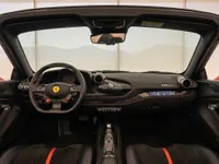 The luxurious cockpit of the Ferrari F8 Spider in Zurich, showcasing its steering wheel, dashboard, and red stitching details.