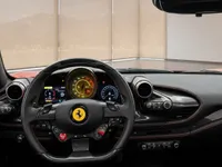 The luxurious cockpit of the Ferrari F8 Tributo in Lausanne, featuring the steering wheel, digital dashboard, and carbon fiber accents.