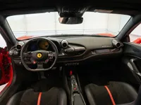 The luxurious cockpit of the 2022 Ferrari F8 Tributo in Lausanne, showcasing the steering wheel, dashboard, and red-accented seats.