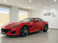 The red Ferrari Portofino convertible is showcased from a front three-quarter angle in an indoor showroom in Madrid.