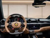 The luxurious interior of the Ferrari Portofino in Zurich, featuring its tan leather steering wheel, dashboard, and central display.
