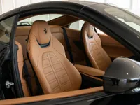 The interior of the Ferrari Portofino in Zurich, showing the luxurious tan leather seats and open door.