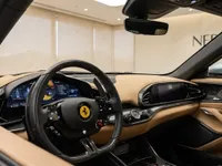 View of the Ferrari Purosangue's luxurious cockpit in Lausanne, featuring the steering wheel, digital dashboard, and tan leather interior.