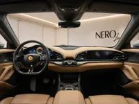 The luxurious tan leather interior of the Ferrari Purosangue in Lausanne, featuring the steering wheel, dashboard, and digital displays.