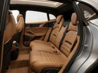 Ferrari Purosangue's luxurious rear interior features tan leather seats, visible from the open passenger door in Lausanne.