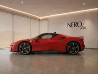The red Ferrari SF90 Stradale supercar is parked in a showroom, showcasing its sleek side profile in Lausanne.