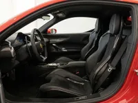 The luxurious interior of the Ferrari SF90 Stradale in Lausanne, featuring black racing seats, steering wheel, and dashboard.