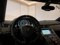 The luxurious cockpit of the Lamborghini Aventador SVJ in Lausanne, featuring the steering wheel, digital dashboard, and central console.