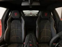 The luxurious interior of the Lamborghini Aventador SVJ in Matte Red, showcasing black Alcantara seats with vibrant stitching in Lausanne.