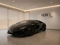 A sleek gloss black Lamborghini Huracán Coupé is showcased in a modern, well-lit showroom featuring the NEROline logo in Zurich.