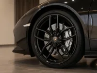 The gloss black front wheel and fender of the Lamborghini Huracán Coupé are prominently displayed in Zurich.