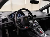 The luxurious black interior of the Lamborghini Huracán Coupé in Zurich, featuring the steering wheel, dashboard, and central console.