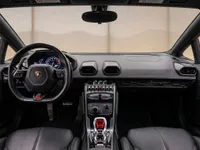 The luxurious black leather interior and driver's cockpit of the Lamborghini Huracán in Zurich, featuring the steering wheel and central console.