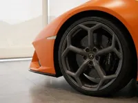 Close-up of the matte orange Lamborghini Huracán EVO Spyder's front wheel, showing the dark grey rim and brake caliper in Zurich.