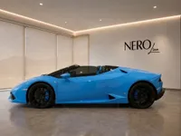 A bright blue Lamborghini Huracán Spyder convertible is parked in a modern showroom with the NEROline logo in Zurich.