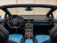 Lamborghini Huracán Spyder's luxurious black and blue interior, showcasing the dashboard, steering wheel, and open top in Zurich.