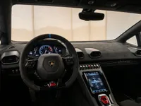 The luxurious cockpit of the 2022 Lamborghini Huracán STO in Lausanne, featuring its steering wheel, digital dashboard, and central console.