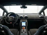 The luxurious interior of the Lamborghini Huracán STO in Lausanne, featuring its steering wheel, dashboard, and central infotainment screen.