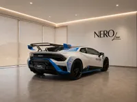 White and blue Lamborghini Huracán STO, 2022 model, shown from the rear three-quarter angle in a Zurich showroom.