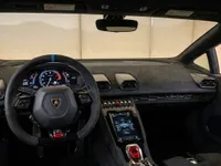 The luxurious black and blue interior of the Lamborghini Huracán STO, featuring the steering wheel, dashboard, and central console.
