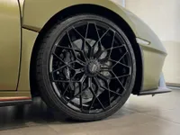 A close-up view of the black multi-spoke front wheel and green fender of the Lamborghini Huracán STO in Zurich.