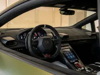 The luxurious cockpit of a green Lamborghini Huracán STO, featuring the steering wheel, dashboard, and central console, available in Zurich.