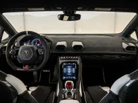 The luxurious interior of the Lamborghini Huracán STO in Zurich, featuring its advanced dashboard, sporty steering wheel, and carbon fiber seats.