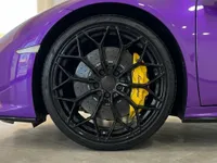 イビサにある紫色のランボルギーニ ウラカン EVO スパイダーのフロントホイール。黒いマルチスポークリムと黄色のブレーキキャリパーが特徴です。