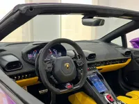 イビサにあるランボルギーニ ウラカン EVO スパイダーの豪華な内装。特徴的なステアリングホイール、デジタルダッシュボード、黄色のアクセントが特徴です。