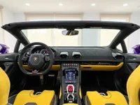 イビサにあるランボルギーニ ウラカン EVO スパイダーの豪華なコックピット内部。黄と黒のシート、ダッシュボード、ステアリングホイールが特徴です。