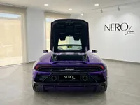 鮮やかな紫色のランボルギーニ ウラカン EVO スパイダーがイビサのショールームに駐車されており、トランクが開いた状態で後方から見た様子。
