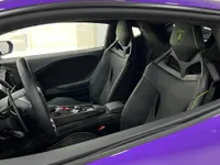 The interior of the Lamborghini Temerario in Madrid, featuring black leather sport seats with vibrant green stitching and a view of the steering wheel.