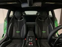 The luxurious interior of the 2025 Lamborghini Temerario in Zurich, showcasing black sport seats with vibrant green stitching and accents.