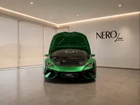 The gloss metallic green Lamborghini Temerario is displayed head-on in a Zurich showroom with its front hood open, revealing the storage.
