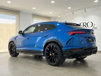 イビサのショールームに駐車された青いランボルギーニ ウルスは、洗練された後方クォータービューと黒いホイールを披露しています。